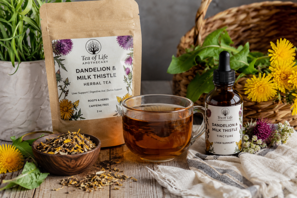 Cup of Dandelion and Milk Thistle herbal tea with matching tincture bottle, surrounded by dandelion flowers, milk thistle blossoms, and dried herbs on a rustic wooden table. This caffeine-free herbal blend supports healthy liver function, natural detoxification, digestion, and overall wellness.