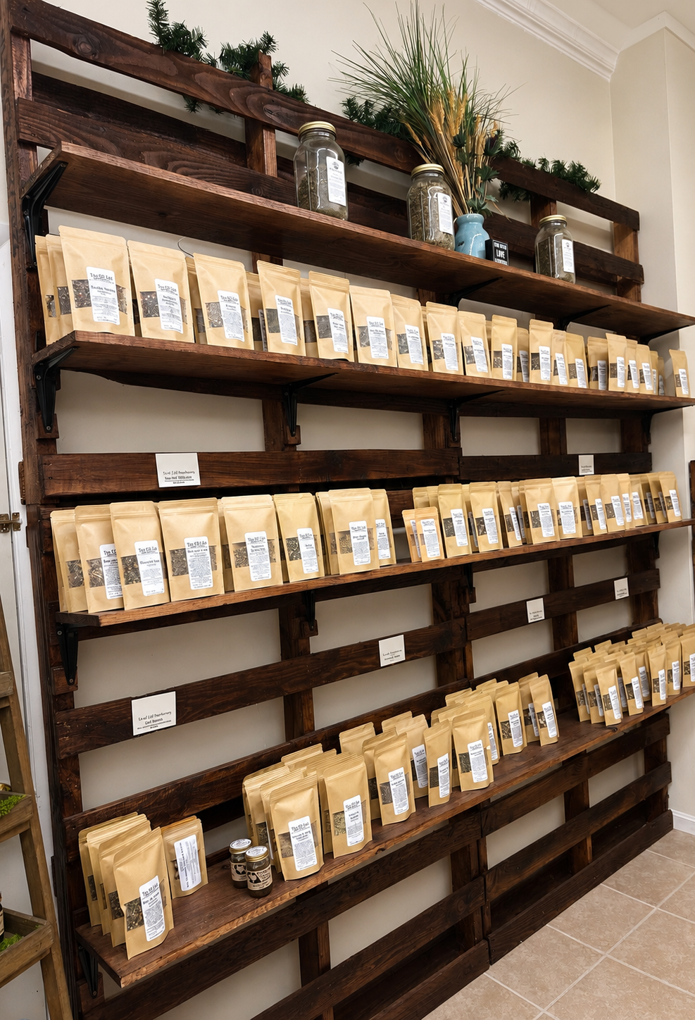 Rustic wooden wall display featuring Tea of Life Apothecary's handcrafted herbal tea blends arranged on custom shelves in a warm, inviting wellness shop in Chillicothe, Ohio.